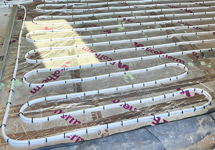 Individual tacker clips securing water underfloor heating pipe to insulation