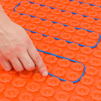 close up of electric underfloor heating cable being installed in a decoupling membrane