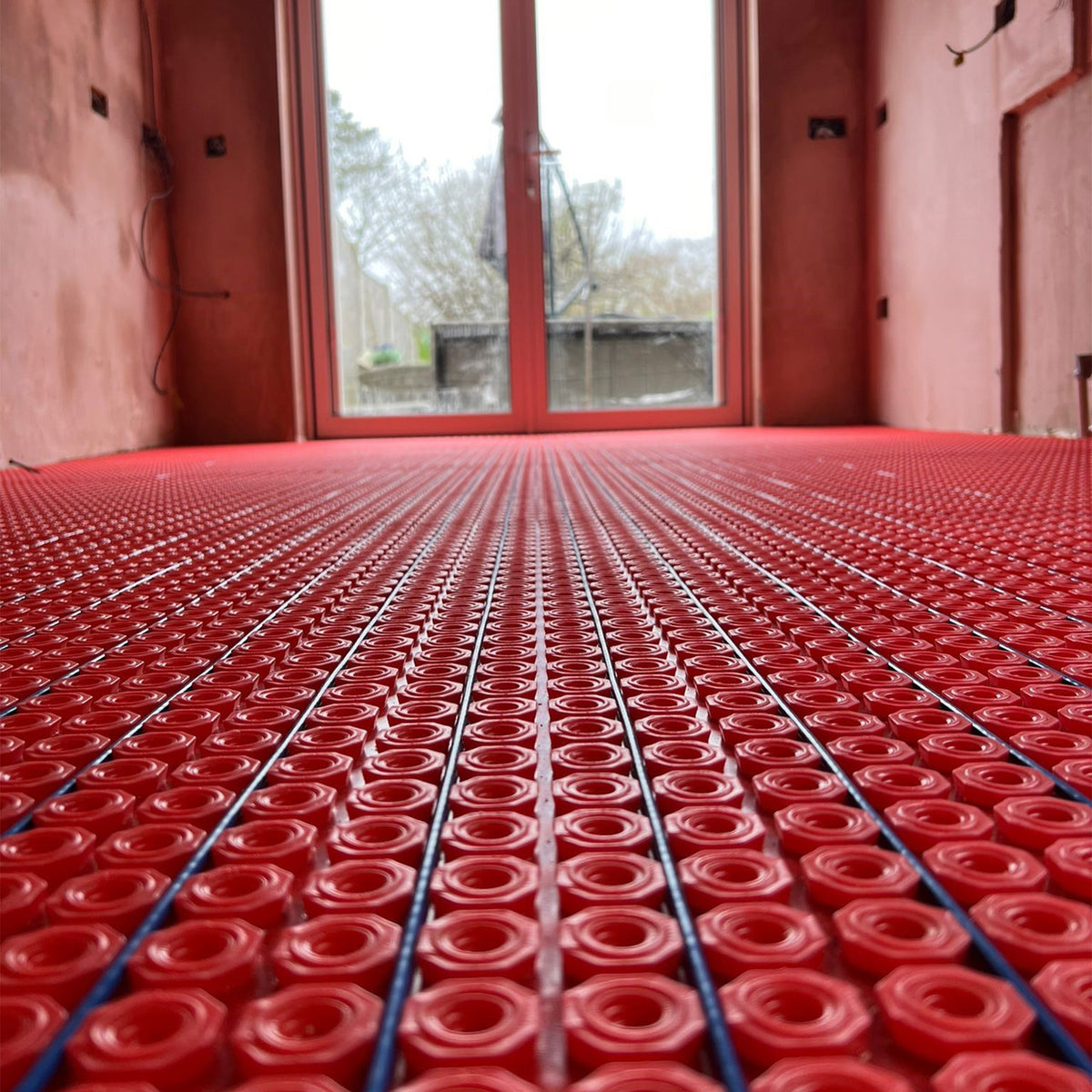 Electric underfloor heating cable being installed in a decoupling membrane