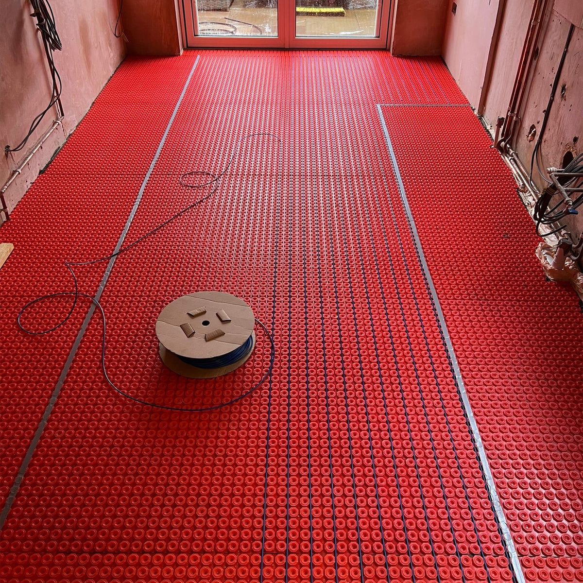 Floor heating cable installation in decoupling membrane