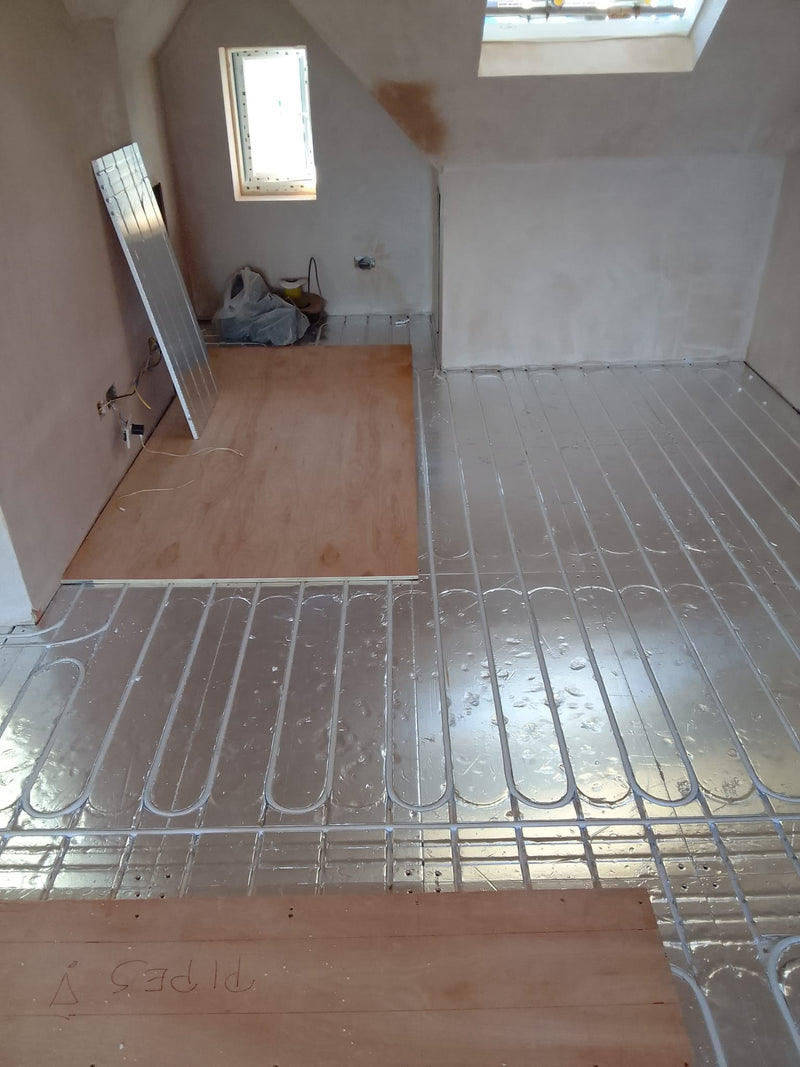 AD-EPS400 foil-faced floor panels with heating pipe installed around a room and doorway