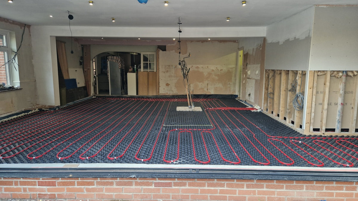 Completed AD-TRAY pipe layout viewed across a large room before screeding