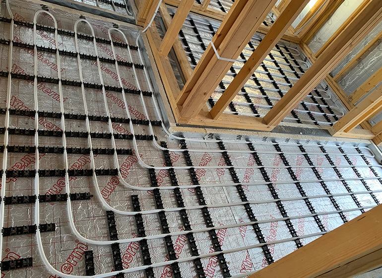 Water underfloor heating pipework installed across floor insulation